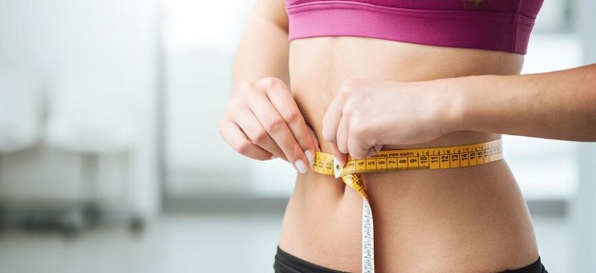 A girl measures her waist