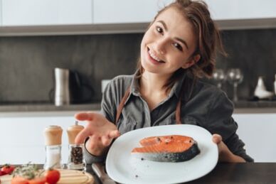 A young girl with a trout steak